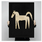 Person holding large abstract horse canvas art print showing scale — black background with cream horse silhouette