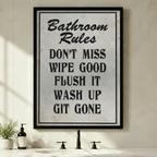 Framed funny Bathroom Rules quote canvas wall art with vintage distressed white texture and bold black typography reading Don't Miss Wipe Good Flush It Wash Up Git Gone displayed above a bathroom sink with green plants