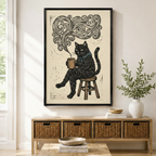 Framed black cat holding coffee mug woodblock print wall art displayed above a rattan console table in a bright modern entryway