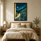 Black-framed canvas wall art featuring a black cat overlooking a moonlit European village with warm glowing windows and a lush hillside, styled above a neutral linen bedroom bed