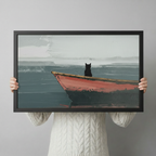 Hand-held size reference of framed black cat on red wooden boat wall art print with misty lake background in landscape orientation