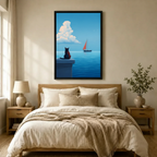 Black-framed canvas art of a solitary black cat watching a red sailboat on a peaceful blue ocean, hung above a neutral-toned bedroom bed