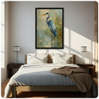 Framed great blue heron canvas wall art hung above a bed in a sunlit minimalist bedroom, nature-inspired oil painting in soft blue and gold palette