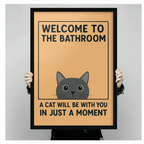 Person holding large framed cat bathroom print showing size — Welcome to the Bathroom funny wall art for cat lovers