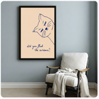 Funny cat quote poster in black frame on blue-grey wall beside white armchair, quirky cat wall art
