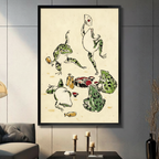 Black framed Japanese ukiyo-e style whimsical illustration of five green spotted frogs at a sake banquet one dancing with a fan one raising a cup one sprawled drunk beside yellow sake bottles red bowls and a feast on aged cream parchment background canvas wall art displayed in a modern gray living room with dark sofa and metal candlesticks
