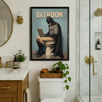 Comic Batman Batroom framed poster on a white marble bathroom wall beside a round mirror with gold sconce, above a toilet with candle tray and trailing green plant next to a glass shower