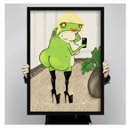 Person holding large black framed glamour frog wall art print with high heels and blonde wig against neutral gray background