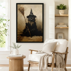 Vintage gothic framed art print of a fierce black cat witch holding a broomstick rendered in moody sepia and brown oil painting tones, styled beside a linen armchair in a cozy reading nook