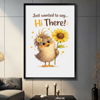 Black framed Just Wanted to Say Hi There funny fluffy chick holding sunflower canvas wall art with white background displayed in a modern dark gray living room with gray sofa, black coffee table and candlesticks