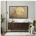 Framed Japandi bird and golden moon nature canvas art hung above dark walnut sideboard in modern living room with brass floor lamp and green velvet accent chair