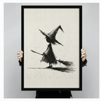 Person holding a black framed canvas print of a minimalist witch with broom sketch, showing actual print size against a neutral grey background
