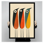 Person holding a large black framed mid-century three abstract birds art print showing print size scale with bold orange teal and yellow color block detail on cream background