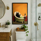 Black framed vintage black cat with wine in bathtub canvas art featuring an elegant green-eyed cat soaking in a teal clawfoot tub holding a wine glass beside a bottle on a wooden stool against a warm orange wall, displayed in a stylish bathroom above a toilet with brass fixtures, round mirror, wooden marble vanity, trailing pothos plant, and glass shower enclosure