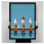 Person holding large black framed print of three seagulls on a pier, showing print size and frame quality detail