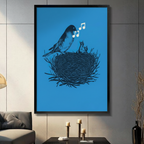 Black framed canvas print of mother bird singing to baby chicks in nest with white music notes on vivid blue background, displayed on grey wall above console table with candles