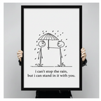 Person holding large framed stick figure couple sharing umbrella in rain canvas print with both hands - close up view of minimalist black and white romantic love quote wall art with clean hand-drawn illustration and black frame finish