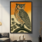 Vintage linocut style great horned owl with orange eyes perched on a branch framed wall art in black frame on a dark gray living room wall above a console table with black candle holders, gray sofa, and tall black vase