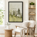 Black framed watercolor white cat and black dog in a pine forest canvas art showing a little cat and dog standing close together on a soft green hillside among misty fir trees with the you complete my heart quote in gentle sage watercolor, displayed on a white wall beside a light upholstered wooden armchair draped with a cream fringed throw blanket near a shelf of plants