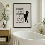 Welcome to the Bathroom black cat framed canvas above freestanding bathtub in Nordic bathroom with gold sconce round mirror and oak vanity - funny cat wall art for spa-style bathroom decor