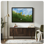 Black framed whimsical cat duo watercolor landscape print above a dark walnut sideboard with stacked books and a succulent, beside a gold floor lamp and olive green armchair in a modern living room
