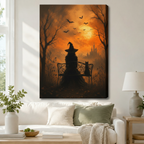 Stretched canvas halloween art print of a witch and black cat silhouette on a garden bench surrounded by bare trees and bats under an amber moonlit sky, hung above a white sofa in a living room