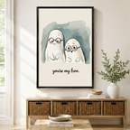You're My Boo cute ghost couple with glasses watercolor framed wall art in black frame displayed above a wooden sideboard with wicker baskets in a bright Scandinavian entryway